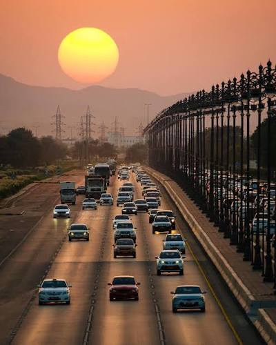 Vehicles on an Omani highway at sunset